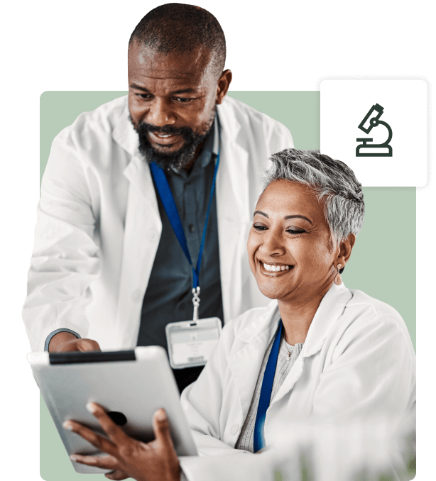 Two healthcare professionals reviewing cardiology information on a tablet with engagement and focus.