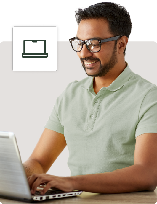 A smiling man with glasses working contentedly on his laptop at a desk, with an icon symbolizing file storage in the background.
